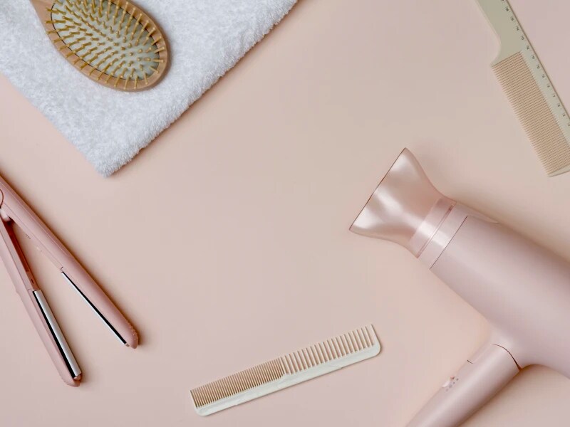 ドライヤー、ブラシ、タオル、コーム、ヘア用アイロンが並んでいる