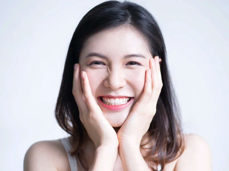 両頬に手を当てて嬉しそうに笑っている女性