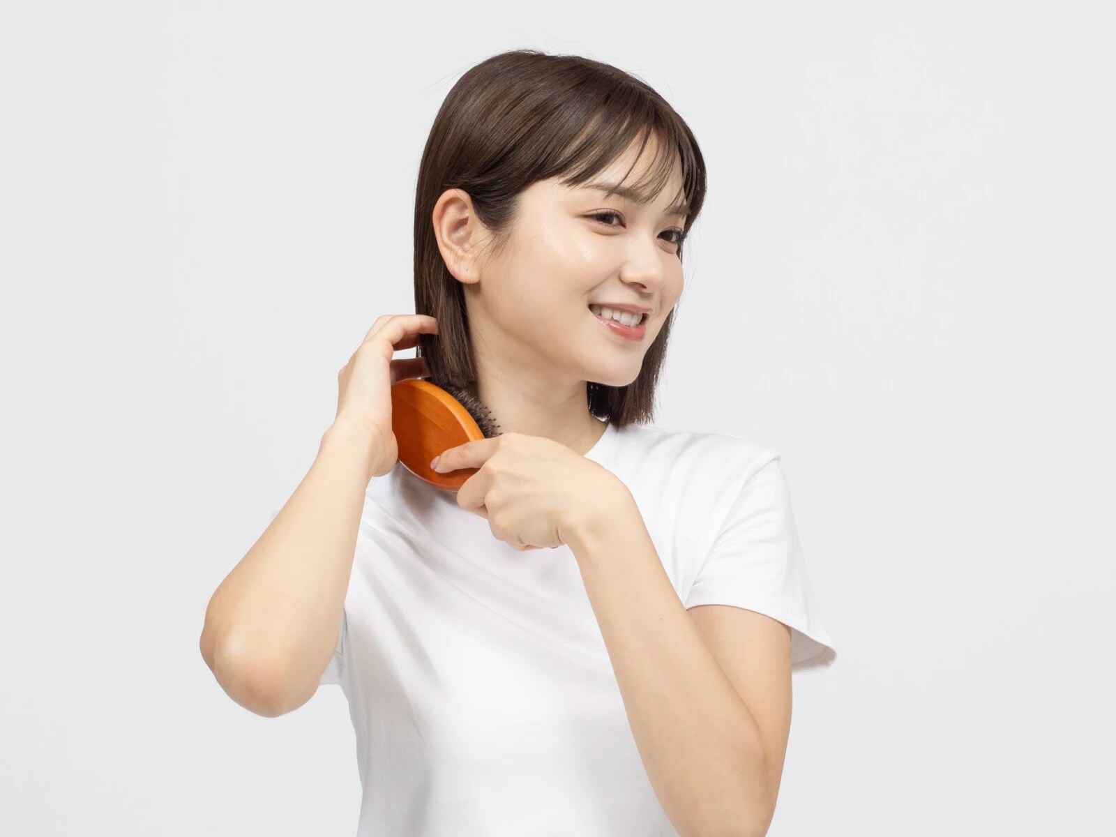 ブラシで髪をとかしている笑顔の女性