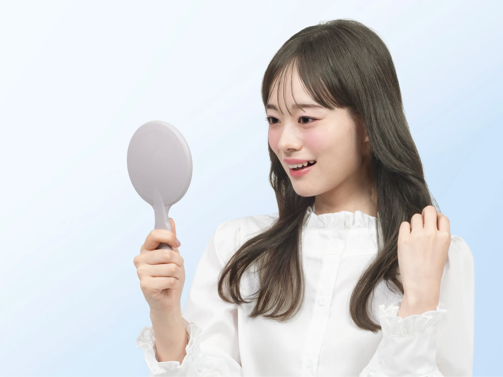 ビューティラボ/ミスティアッシュの髪色をして手鏡で髪を見て笑顔を浮かべている女性