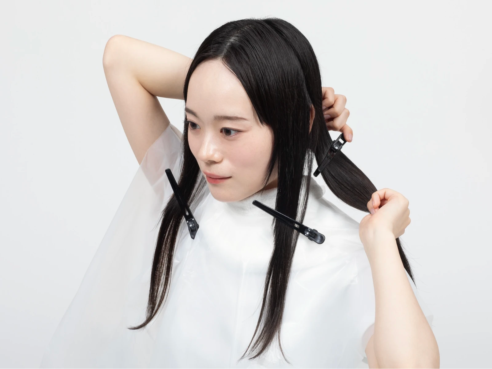 ケープを巻いてダッカールで髪をブロッキングしている女性