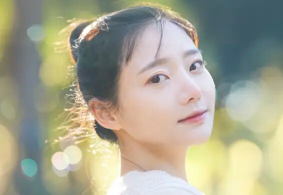 明るめのブラウン系の髪色をしてこちらを向いている女性