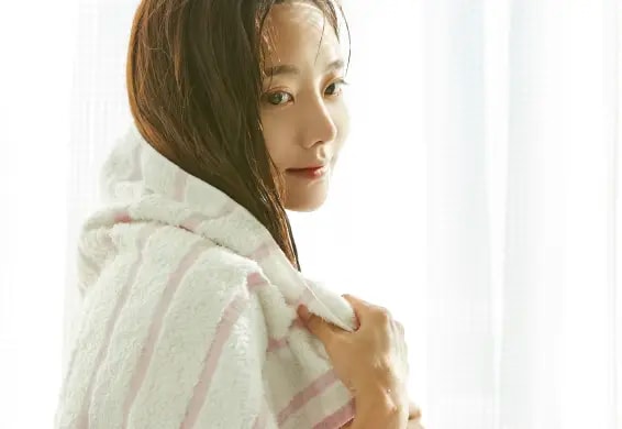 洗髪後の濡れた髪をタオルで拭いている女性